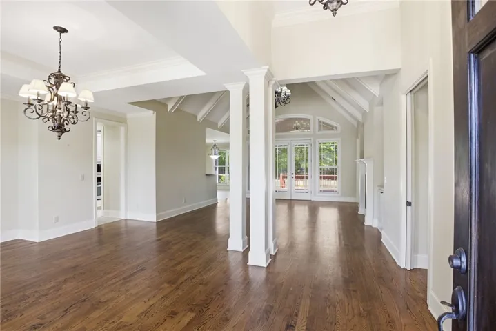 Enter into a spacious interior featuring high ceilings and beautiful hardwood floors.