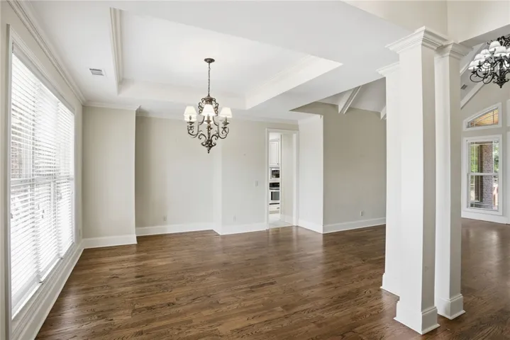 This expansive room features beautiful hardwood flooring and high ceilings, creating an inviting atmosphere.