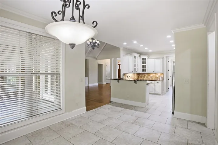 This bright kitchen and dining area features elegant cabinetry and recessed lighting.