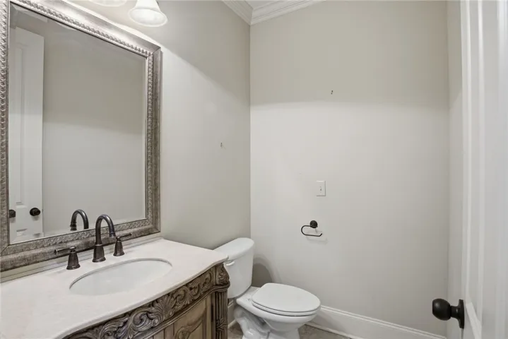 This bathroom features an elegant vanity with ornate detailing and a well-appointed mirror.