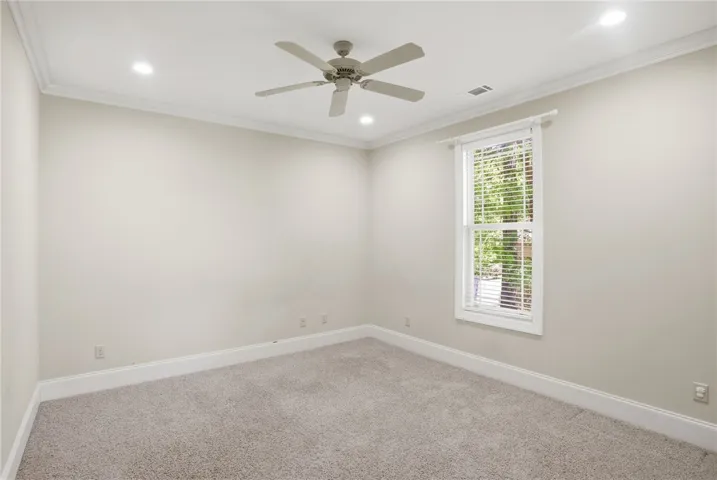 This serene bedroom offers a tranquil retreat with plush carpeting and bright natural light.