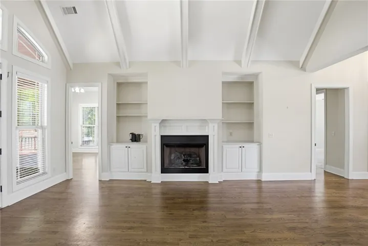 This bright living area features vaulted ceilings and a classic fireplace, perfect for gatherings.