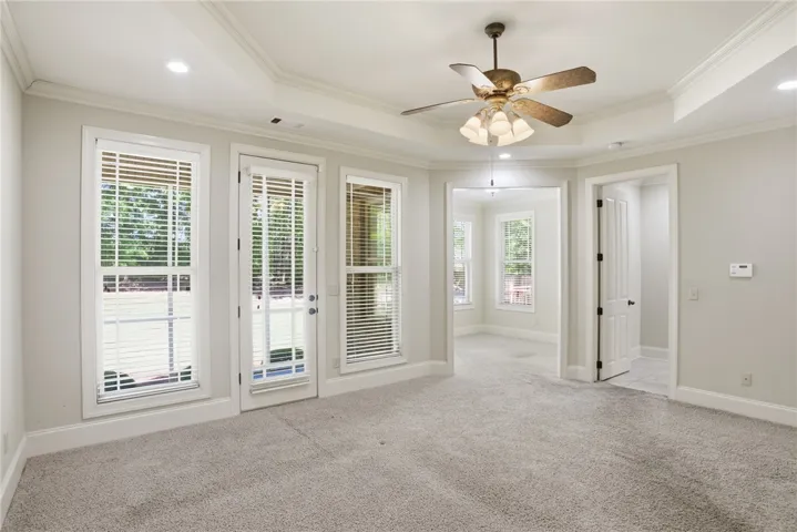 This bright and airy room offers carpeted floors and multiple windows, providing a tranquil atmosphere.