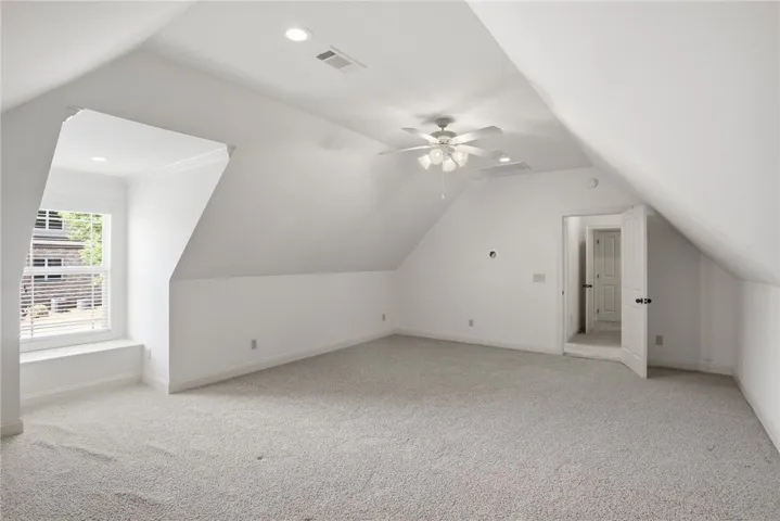This spacious attic boasts plush carpeting and abundant natural light, perfect for flexible living.