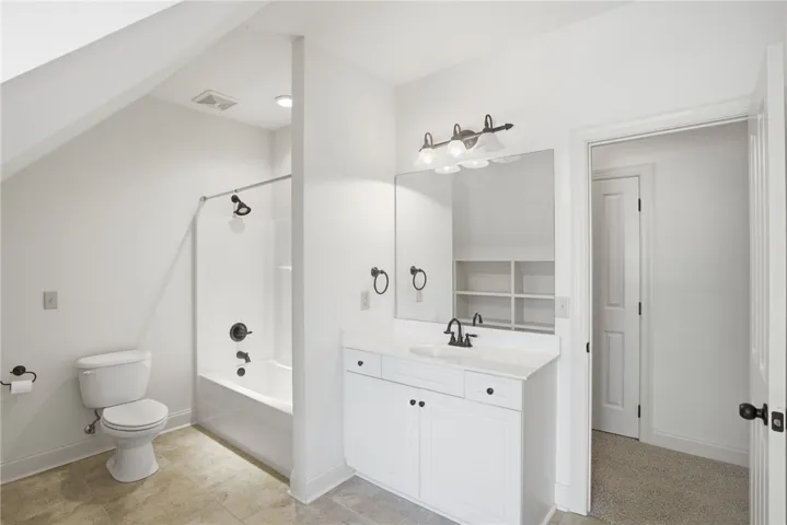 This bright bathroom features a spacious tub and a clean, functional vanity.