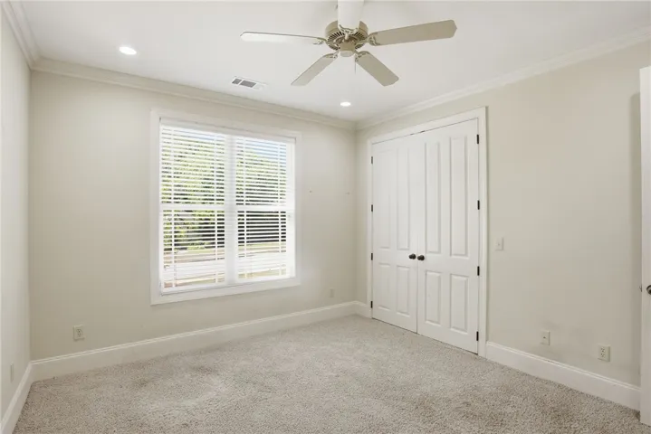 This airy bedroom offers a comfortable retreat with ample natural light.