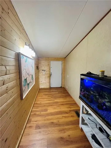 This cozy hallway features warm wood paneling and durable wood flooring.