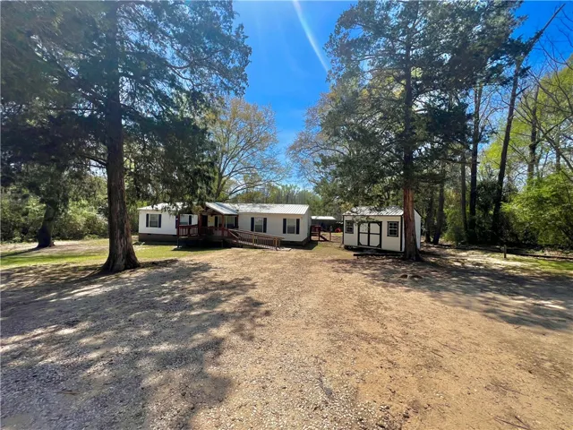 This residence features a welcoming facade with a ramp for easy access, nestled among mature trees.