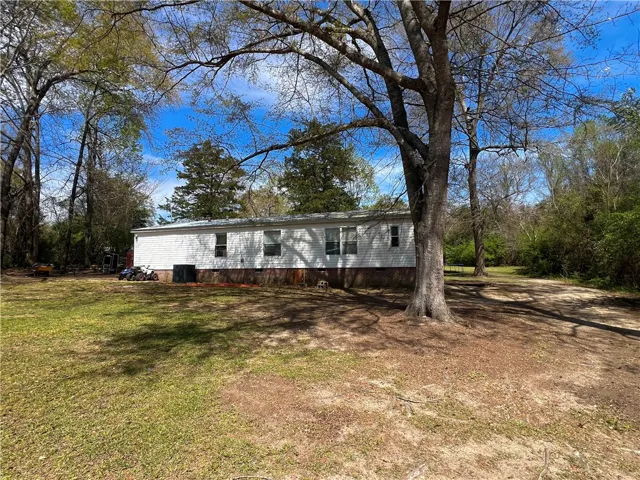This expansive yard offers ample space, surrounded by mature trees for natural beauty.