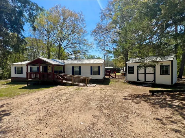 This charming residence features a welcoming porch and practical outdoor storage.
