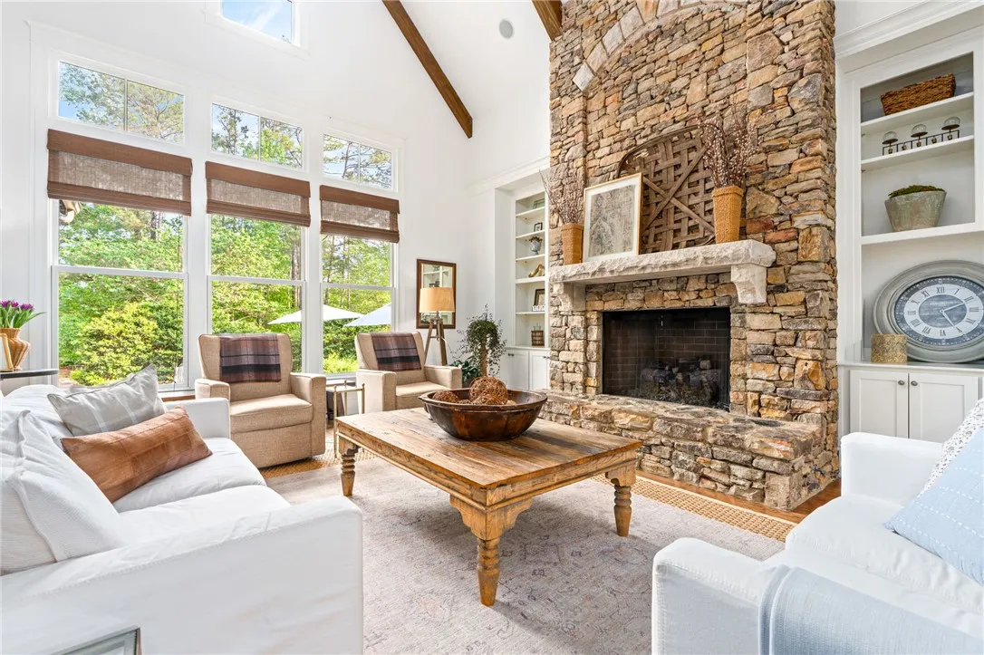 A vaulted ceiling with wood beams and stone fireplace steals the spotlight in this breathtaking living room.