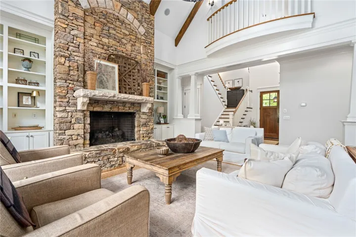 A vaulted ceiling with wood beams and stone fireplace steals the spotlight in this breathtaking living room.