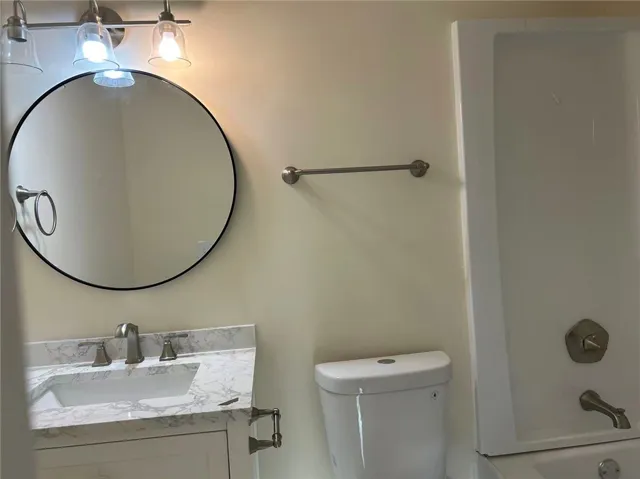 This clean and inviting bathroom features a modern vanity and ample lighting for daily routines.