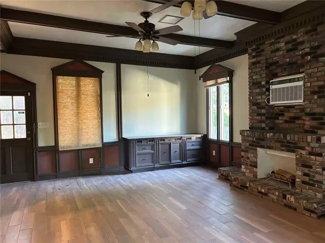 This spacious living area offers wood flooring, a fireplace, and built-in storage.
