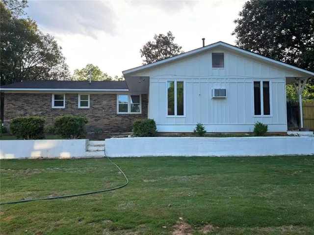 This charming home features a lovely brick exterior and a well-maintained lawn.