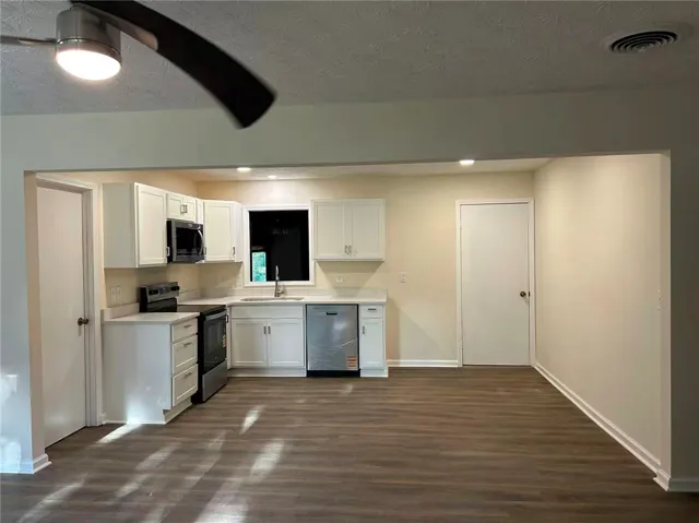 This spacious area combines a functional kitchen with an inviting living space.