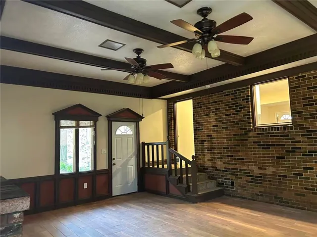 Warm wood tones complement exposed brick in this inviting living space.