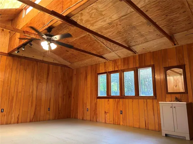 This bright space features inviting wood paneling and large windows, creating a warm and airy atmosphere.