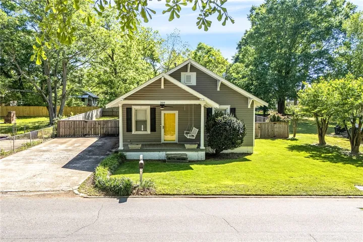 This charming residence features a well-maintained lawn and inviting front porch, offering delightful curb appeal.