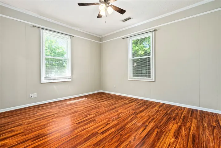 This spacious room features ample natural light and durable flooring, offering a comfortable living space.