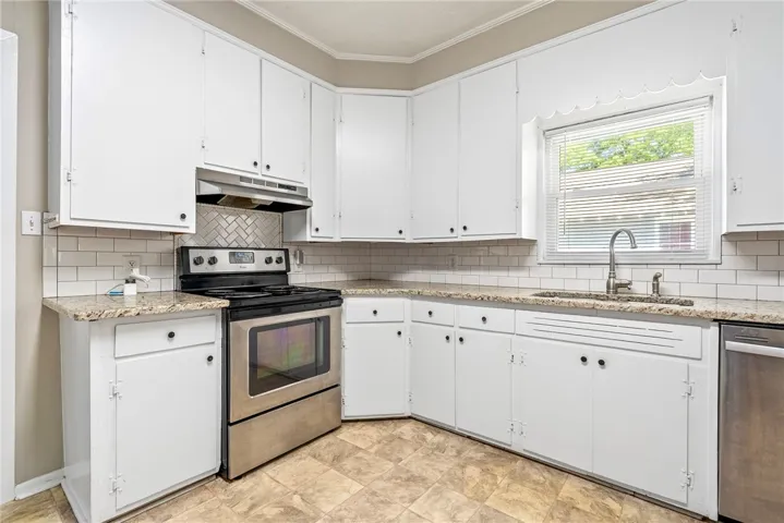 Bright and functional, this kitchen offers ample cabinetry, modern appliances, and a lovely window view.