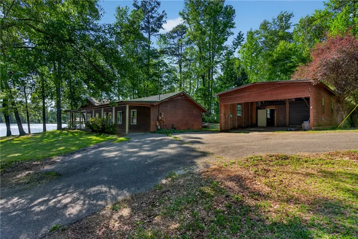 This tranquil lakeside property offers a rustic retreat with ample outdoor space and potential.