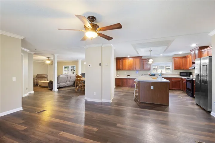 This expansive kitchen and living area features rich wood flooring and a functional island.