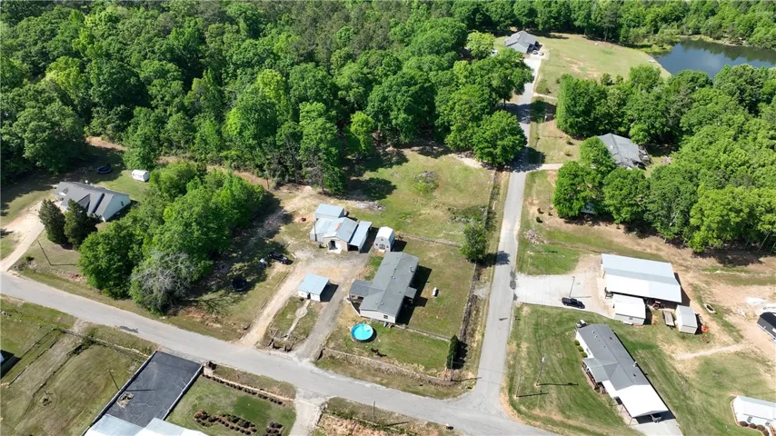 This expansive property features a serene lake, a refreshing pool, and ample space for outdoor living.