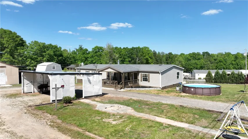 This property features a charming residence with an inviting porch and a refreshing above-ground pool.