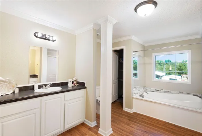 This spacious bathroom offers a relaxing soaking tub and ample vanity space.