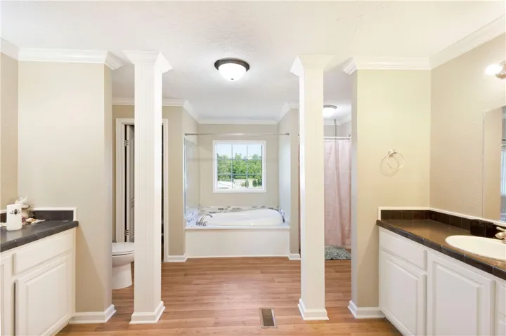 This bathroom provides a large soaking tub and separate vanities, creating a peaceful personal retreat.