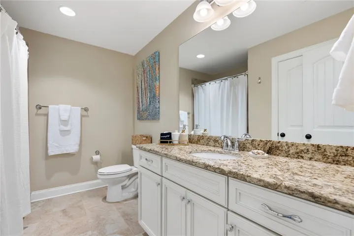 This bathroom features a sleek vanity with ample storage and elegant finishes.