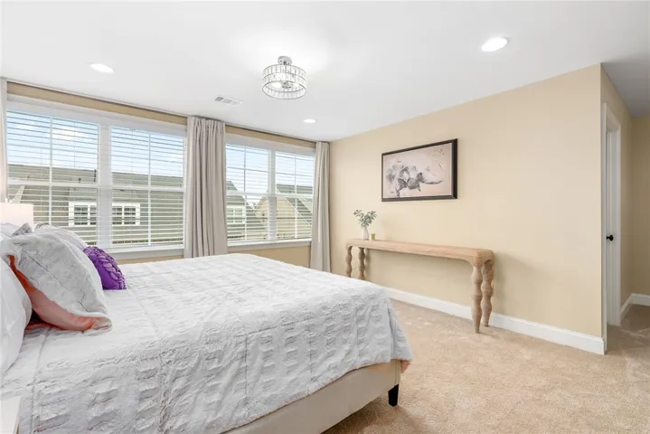 This spacious bedroom offers ample natural light and a serene retreat for relaxation.