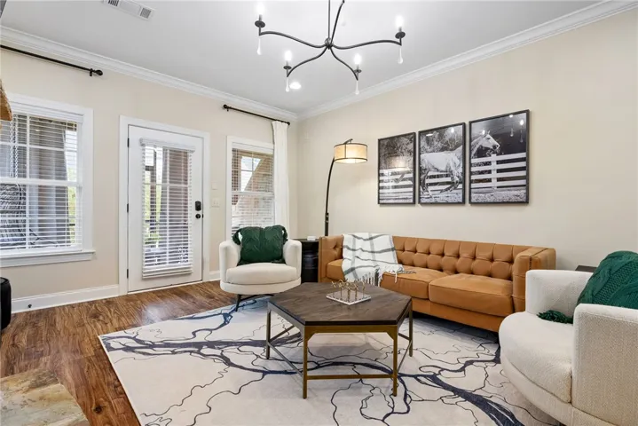 This inviting living space features warm hardwood floors, crown molding, and abundant natural light.