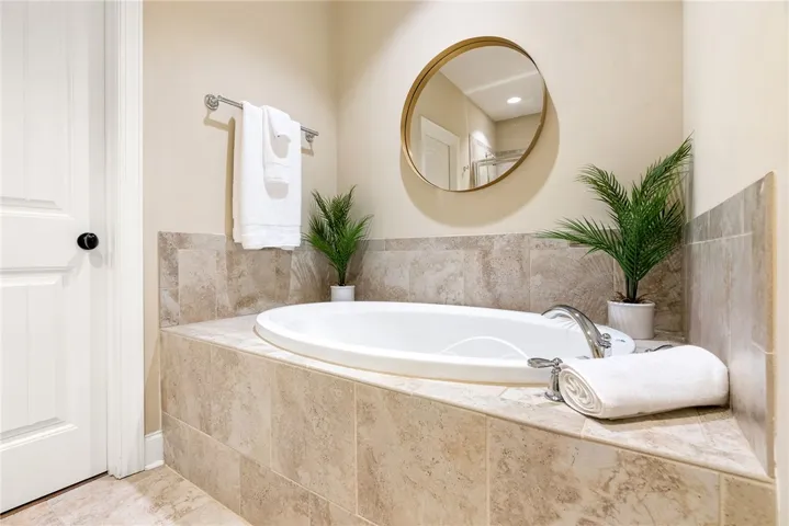 Relax in this inviting bathroom featuring a deep soaking tub and elegant tile finishes.