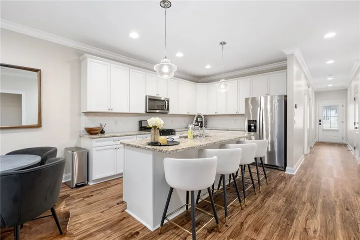 This bright kitchen with a granite island offers a seamless transition to the inviting entry.