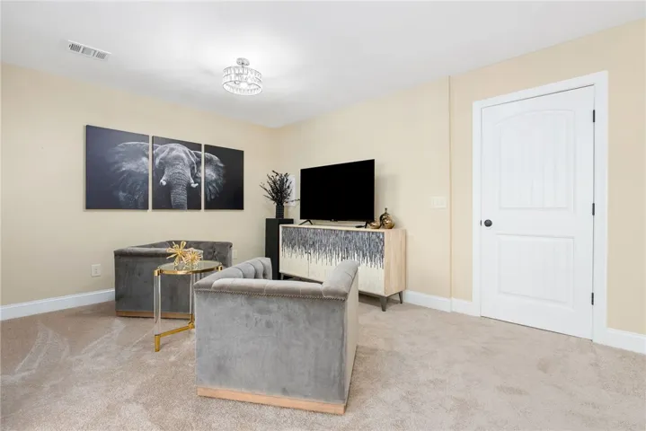 This cozy living space offers plush carpeting and a classic paneled door.