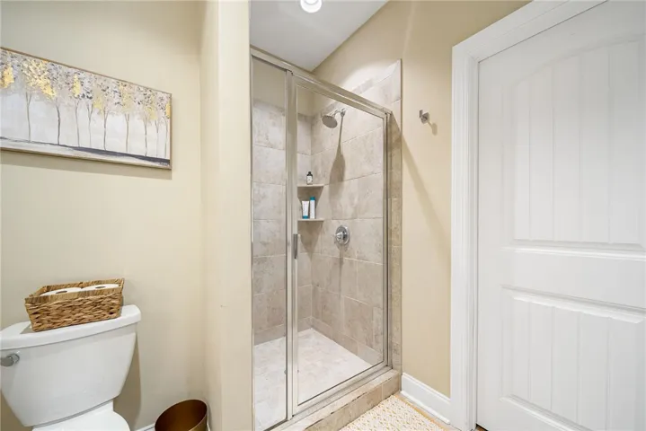 This bathroom features a sleek glass-enclosed shower and durable tile flooring.