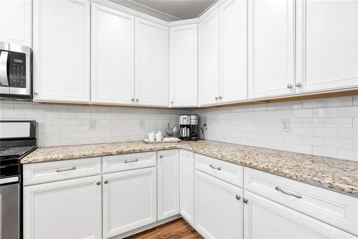 This modern kitchen features crisp white cabinetry and ample counter space, perfect for culinary endeavors.