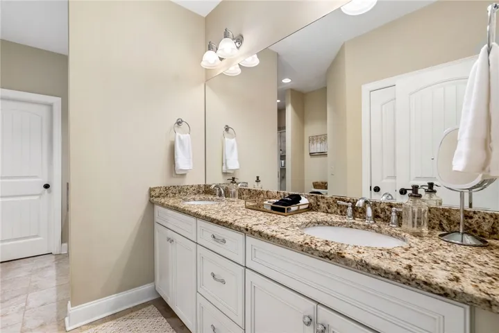 This bathroom features a double vanity with granite counters, offering ample space and elegant finishes.