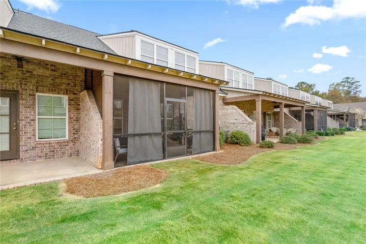 This residence showcases comfortable outdoor living spaces with a neatly maintained lawn.