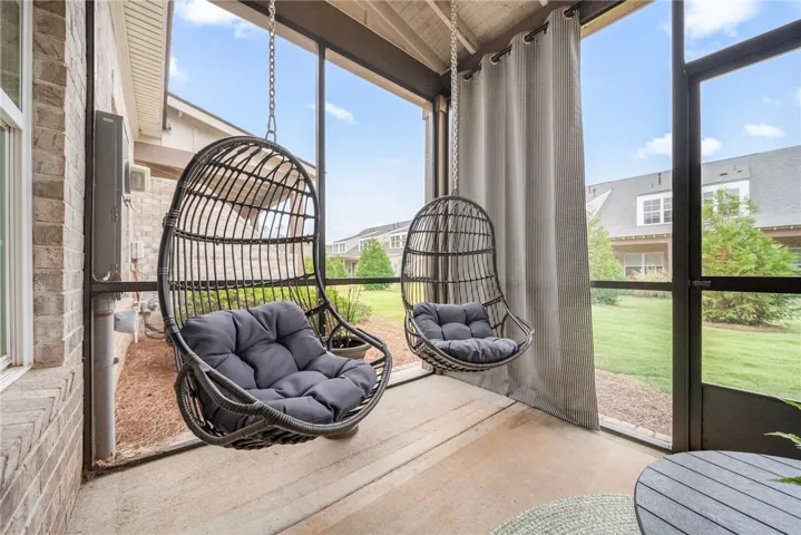 Relax in this screened porch, offering serene views and comfortable seating.