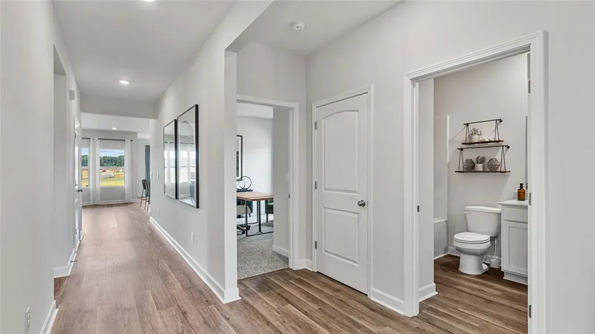 This interior hallway features sleek flooring and bright lighting, guiding visitors to adjacent rooms.