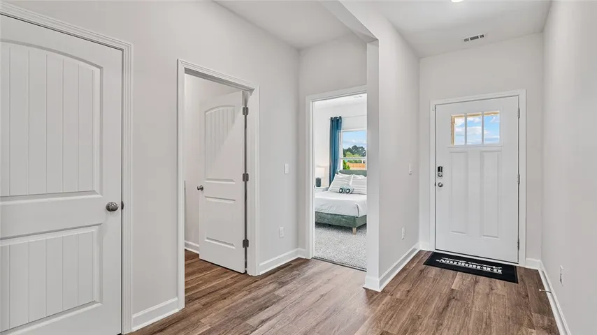 This inviting entry features durable wood flooring, leading to a cozy bedroom.