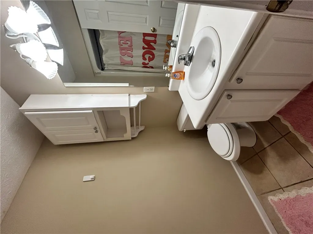 This bathroom features practical storage and easy-care surfaces.