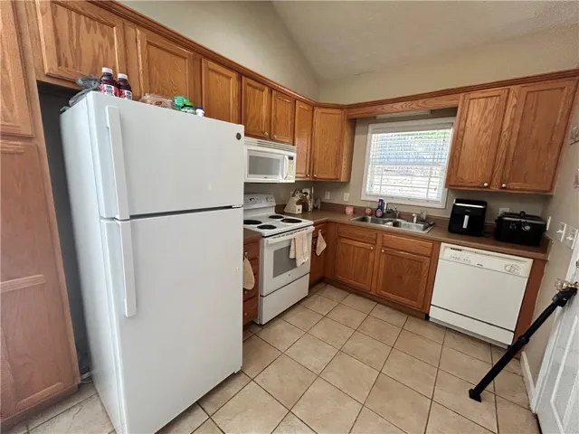 This kitchen features classic wood cabinetry and durable tiled flooring.
