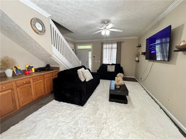 This inviting living space features an elegant staircase and a welcoming entrance.