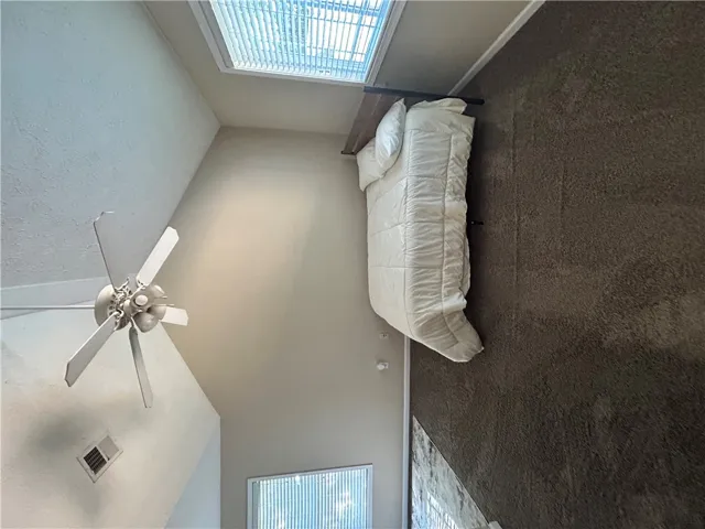 This spacious bedroom features soaring ceilings and ample natural light, perfect for relaxation.