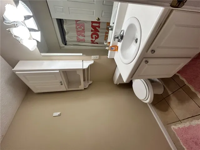 This bathroom features practical storage and easy-care surfaces.