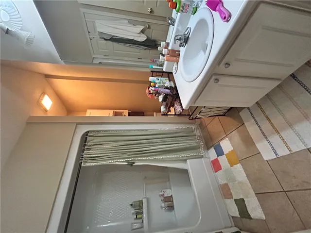 This functional bathroom features a shower and a single vanity for daily routines.